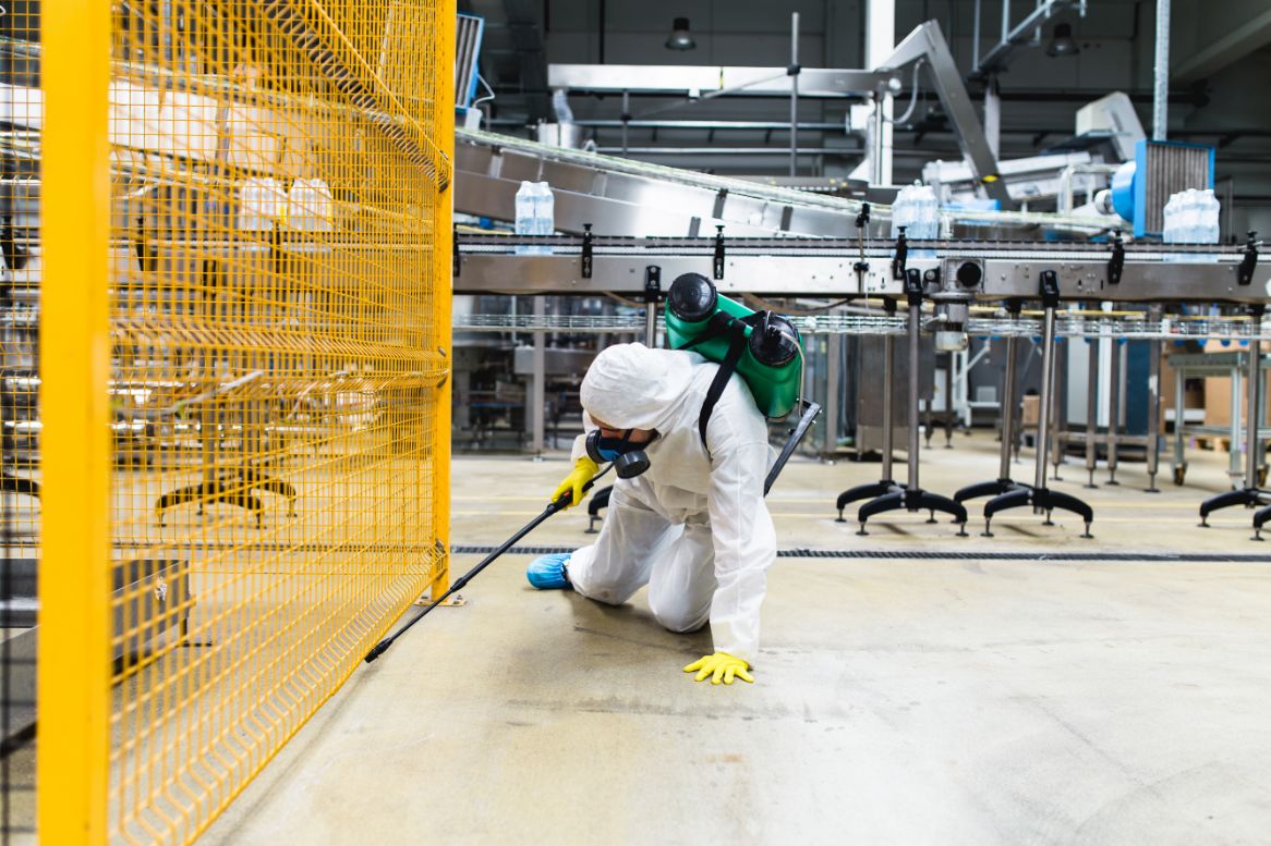 Pest control professional spraying chemical to exterminate rats at a manufacturing hall in Penang
